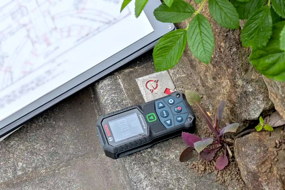 レーザー距離計を用いて前面街路の幅員を調査している様子・藤沢市道路境界金属プレート